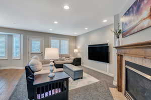 Living area featuring a tile fireplace, baseboards, and recessed lighting