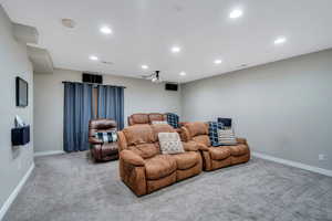 Cinema room with carpet floors, recessed lighting, visible vents, and baseboards