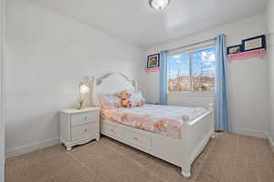 Bedroom featuring light carpet and baseboards