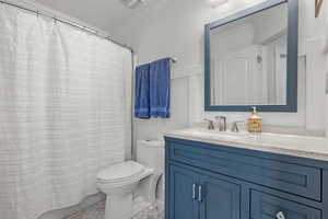 Bathroom with toilet, visible vents, ornamental molding, and vanity