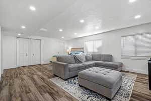 Living area featuring a textured ceiling, recessed lighting, wood finished floors, and baseboards