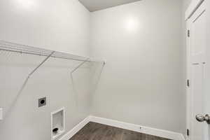 Washroom with baseboards, laundry area, dark wood-type flooring, and hookup for an electric dryer