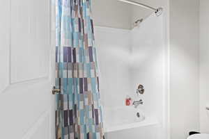 Bathroom with shower / bathtub combination with curtain