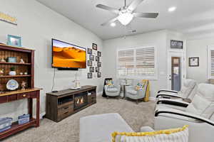 Carpeted living room featuring a ceiling fan, recessed lighting, visible vents, and baseboards