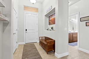 Entrance foyer with light tile patterned floors and baseboards