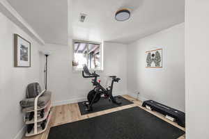 Exercise room featuring baseboards and wood finished floors