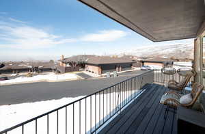 Snow covered back of property with a residential view and a mountain view