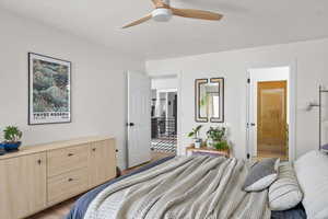 Bedroom with a ceiling fan, light wood-style flooring, and ensuite bathroom