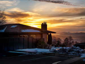 View of front of home with a chimney, a mountain view, and brick siding