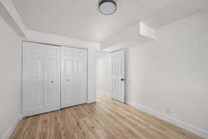 Unfurnished bedroom with baseboards, a closet, and light wood-style floors