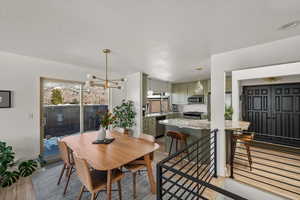 Dining room with light wood-type flooring and an inviting chandelier