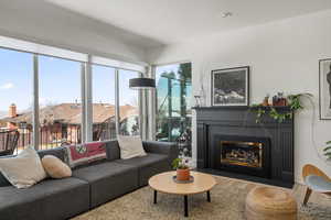 Living area with a fireplace with flush hearth and wood finished floors