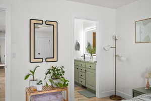 Bathroom featuring wood finished floors, vanity, and baseboards