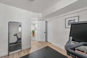 Workout area featuring light wood-style flooring and baseboards