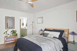 Bedroom featuring dark wood-style floors, ceiling fan, and ensuite bathroom