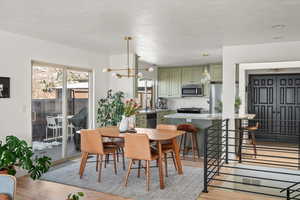 Dining space featuring light wood-type flooring and a notable chandelier