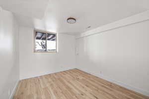 Spare room featuring light wood-style floors, baseboards, and visible vents