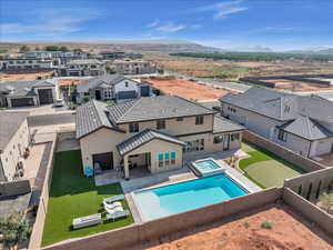 View of swimming pool with a patio, a pool with connected hot tub, a mountain view, a residential view, and a fenced backyard