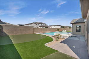 View of pool with a patio area, a fenced backyard, and a pool with connected hot tub