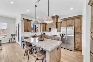 Kitchen featuring visible vents, decorative backsplash, a center island, stainless steel appliances, and a sink