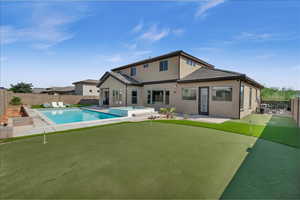 Back of property featuring a pool with connected hot tub, a fenced backyard, a patio, and stucco siding