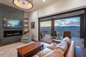 Living area with built in shelves, a mountain view, a fireplace, wood finished floors, and baseboards