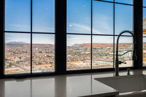 Room details featuring a view of city, stone counters, a sink, and a mountain view