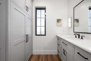 Bathroom with baseboards, wood finished floors, and vanity