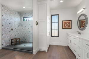 Bathroom with recessed lighting, wood finished floors, vanity, baseboards, and walk in shower