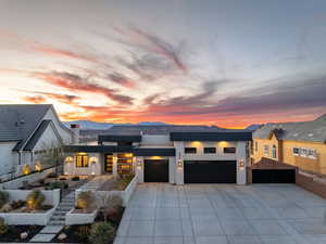 View of front of home featuring a garage, concrete driveway, a mountain view, and stucco siding