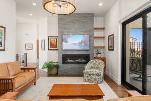 Living area featuring a fireplace, recessed lighting, an inviting chandelier, wood finished floors, and baseboards