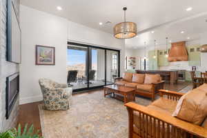 Living room featuring recessed lighting, a fireplace, visible vents, baseboards, and wood-type flooring