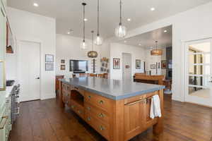 Kitchen with a kitchen island, brown cabinets, dark wood-type flooring, and recessed lighting