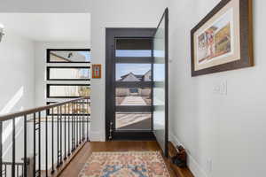 Doorway featuring dark wood-style floors and baseboards