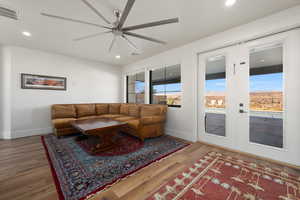 Living room with recessed lighting, wood finished floors, visible vents, and a healthy amount of sunlight