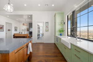 Kitchen with a sink, dark wood-style flooring, green cabinetry, and recessed lighting