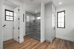 Bathroom featuring a wealth of natural light, baseboards, and wood finished floors