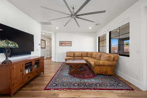 Living room with recessed lighting, visible vents, ceiling fan, wood finished floors, and baseboards