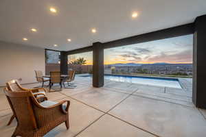 Patio terrace at dusk with a fenced backyard and a fenced in pool