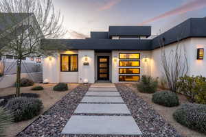 Exterior entry at dusk featuring stucco siding