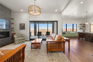 Living room with a fireplace, recessed lighting, visible vents, a chandelier, and hardwood / wood-style flooring