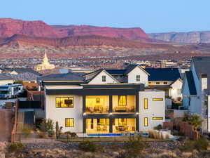 Back of property featuring board and batten siding, metal roof, a mountain view, a balcony, and fence private yard