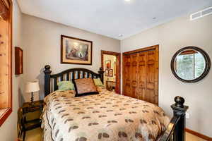 Bedroom with a closet, visible vents, and baseboards