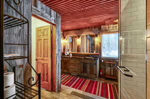 Bathroom with wood ceiling, wood finished floors, and vanity