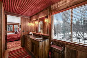 Bathroom with double vanity, ensuite bathroom, a sink, wooden walls, and wooden ceiling