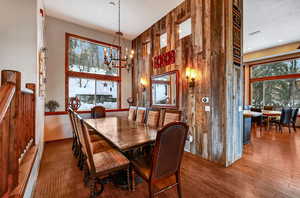 Dining room with a high ceiling, an inviting chandelier, and wood finished floors