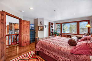 Bedroom featuring a textured ceiling, wood finished floors, and recessed lighting