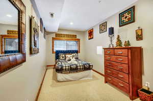 Carpeted bedroom with visible vents, a textured ceiling, and baseboards