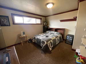 Carpeted bedroom with a textured ceiling and baseboards