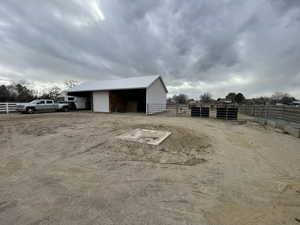 View of pole building featuring fence